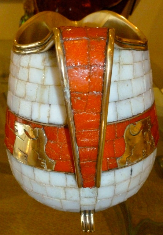 Beautiful inlaid  work of glass mosaic in orange and white, against the Aztec brass symbols, by the master, Salvador Teran in polished brass sits atop 3 brass feet. Signed on the bottom Not photographed... upon request for the hallmarks.
it has