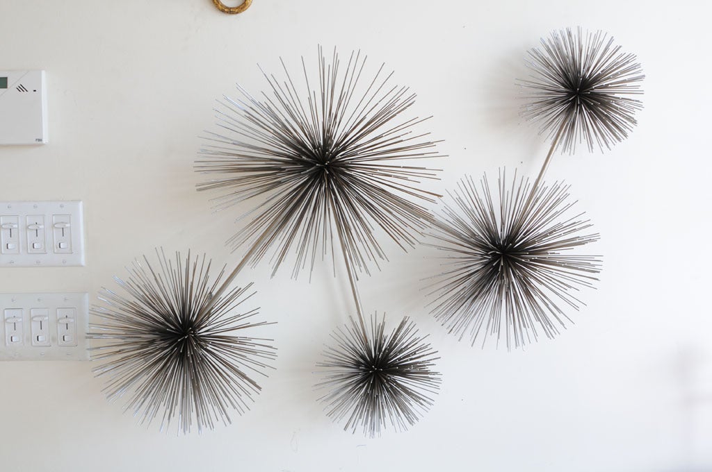 This radiant 5 starburst/ pom pom wall sculpture in steel, makes a statement!
it is dimensional and dramatic... with it's straight rod arms  radiating from all corners.