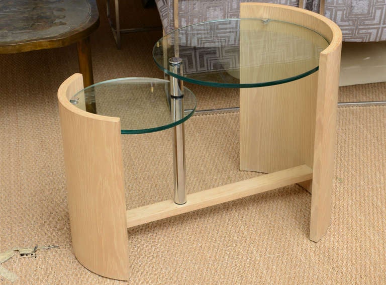 This 2 differentiated heights of the 2 leveled limed  bleached oak and  polished steel and radius glass side table is a classic design by Jay Spectre. It is called the eclipse table.