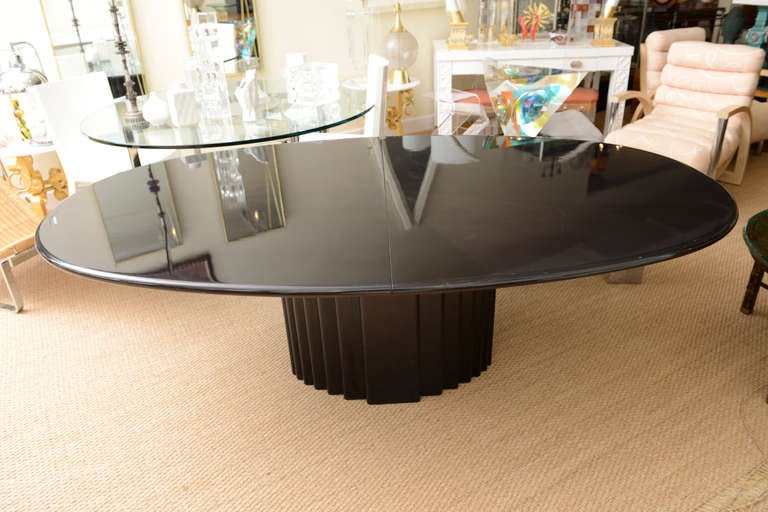This amazing and beautiful Mid-Century Modern Swiss signed rare oval dining table with one leaf is ebonized wood with a high gloss finish. It is pictured here without the leaf on the table. The measurements of the leaf are: 49