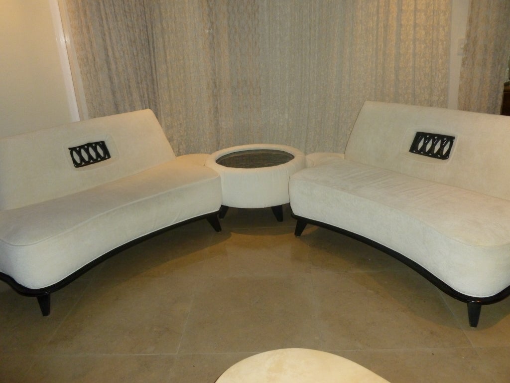 Two sofas connect with a Marble center Round Table covered in off white chenille fabric. The wood ebonized base and the criss cross wood inserts in the back portion of the sofa give it a yin yang, black white...