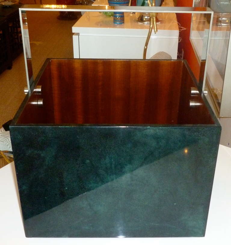 This Italian architectural box steel, lacquered goatskin and wood magazine stand/rack/carrier is signed by Aldo Tura. The luscious color of the teal/emerald green goatskin has beautiful variants of the goatskin and it changes depending on how the
