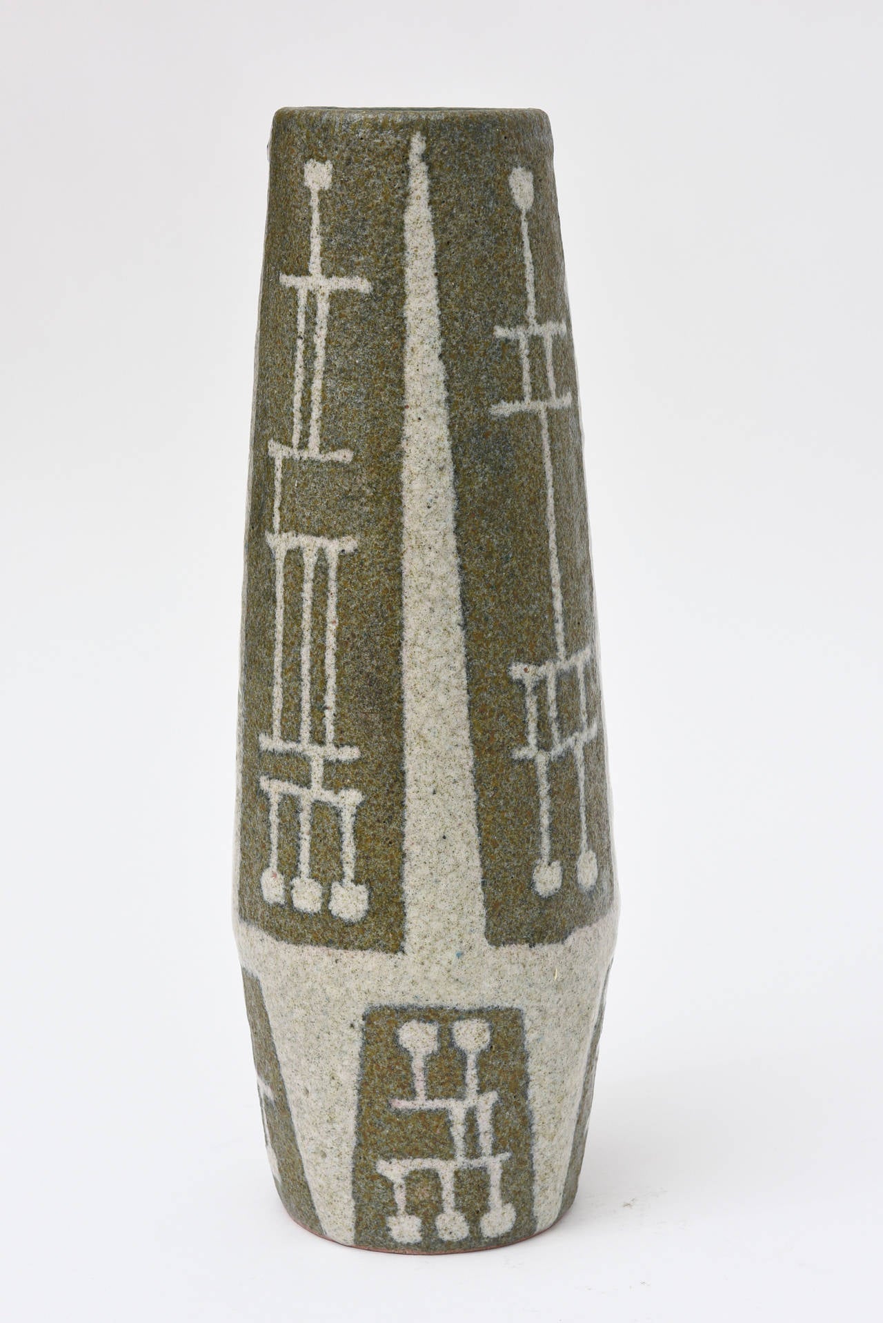 This one of a kind very fine studio ceramic is in the style of Gambone. The Mid-Century stick figures are so modernist. The glazes are triple and textural. The exterior is an olive green/ light brown base with overlay of crème.
The interior color
