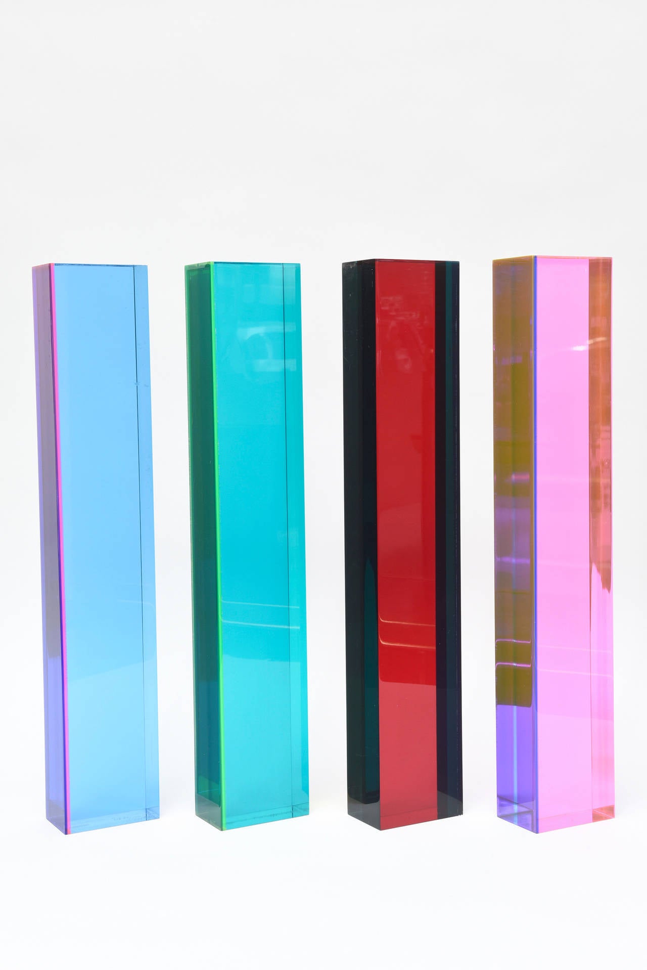 These amazing Mihuch Vasa tall lucite column sculptures; set of four, change with the play and direction of light and placement. They are signed #1156 Vasa 1977. Only one is signed and sold as a set only! The laminated intersecting planes of colored