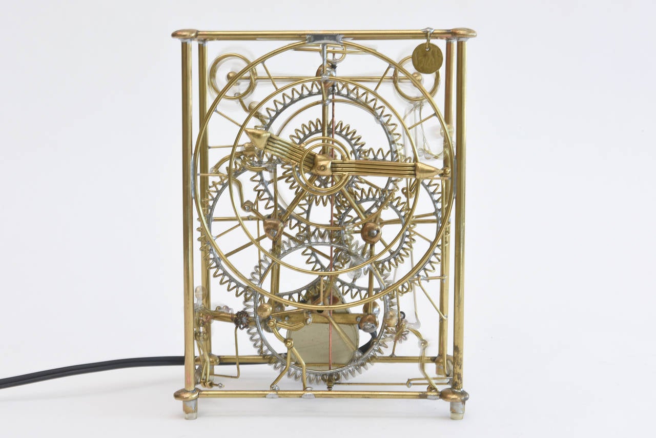 This amazing workable and sculptural clock has all moving pieces of stick figures and Kinetic movement when plugged in. It does tell time and is like a well oiled machine. The stick figures go round and round in full motion along with the
coiled