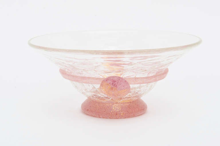 This beautiful italian Murano bowl really needs to be appreciated in person. It has crackled glass and gold aventurine with pink. The gold aventurine globs look like Two medallion appliqués are on either side. 
it has a pate de verre look.
When