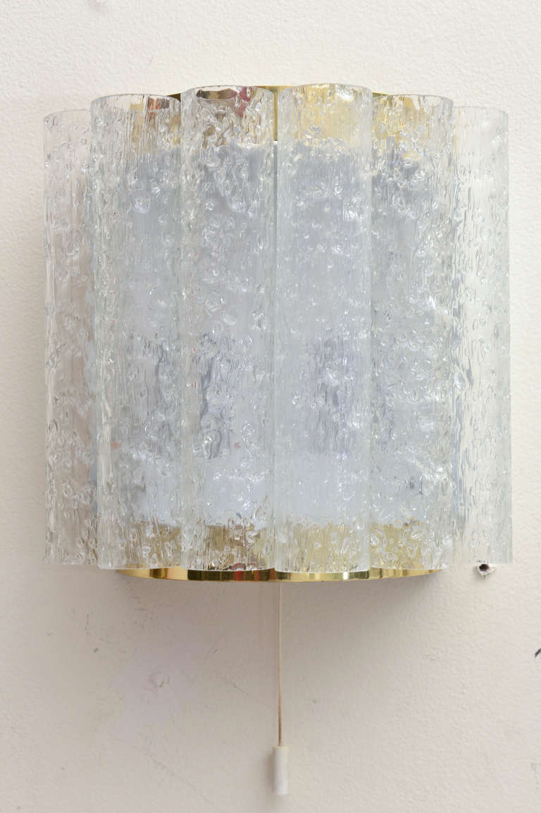These wonderful intimate small German sconces have 6 textured ice glass tubes on each sconce against a white metal plate with semi-circular brass on the top and bottom. They are in great condition and create great atmosphere when lit. They are from