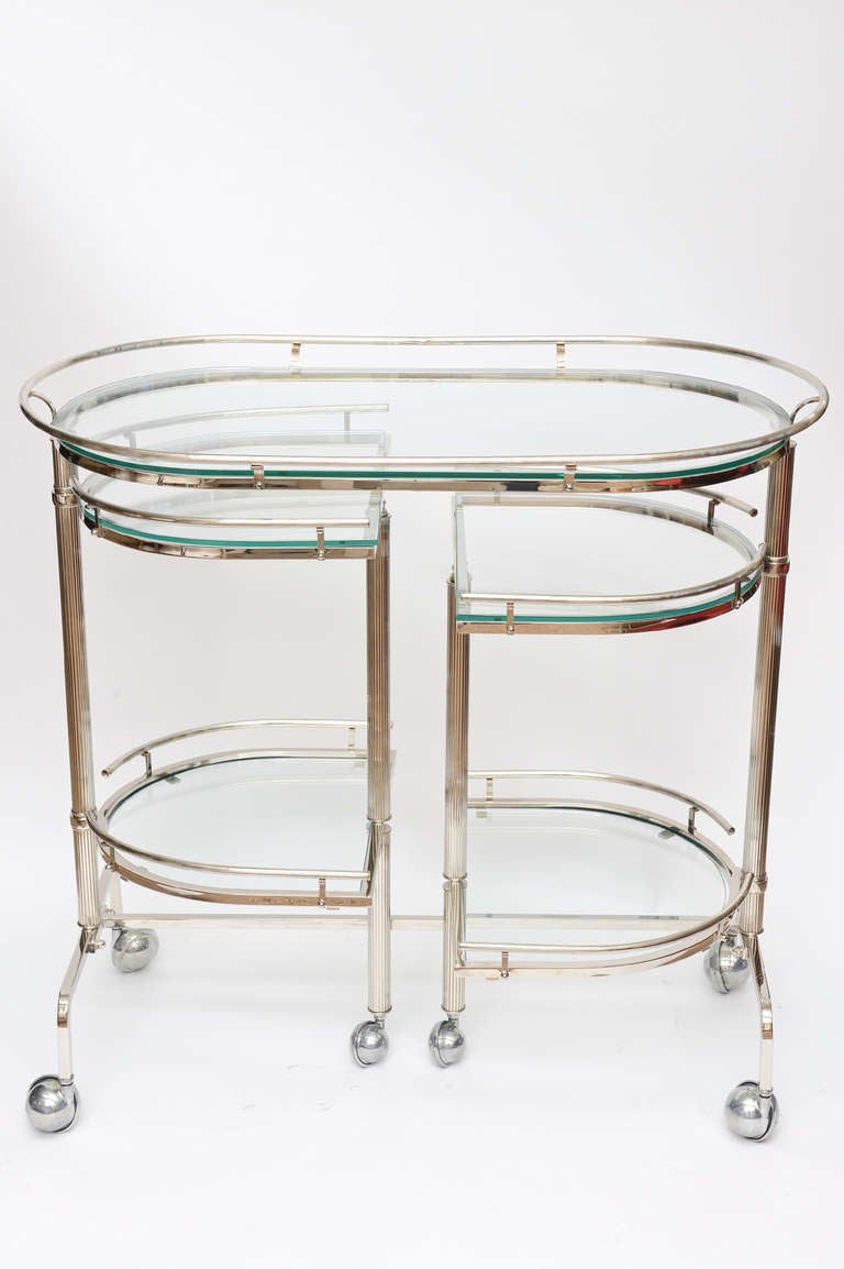 This 3 tiered and pivotal Italian nickel silver and glass bar/serving cart
is fantastic. it is from the 60's and in glorious form both in it's condition but function.
The multi level staggered 4 half moon sections pivot out for serving and drinks.