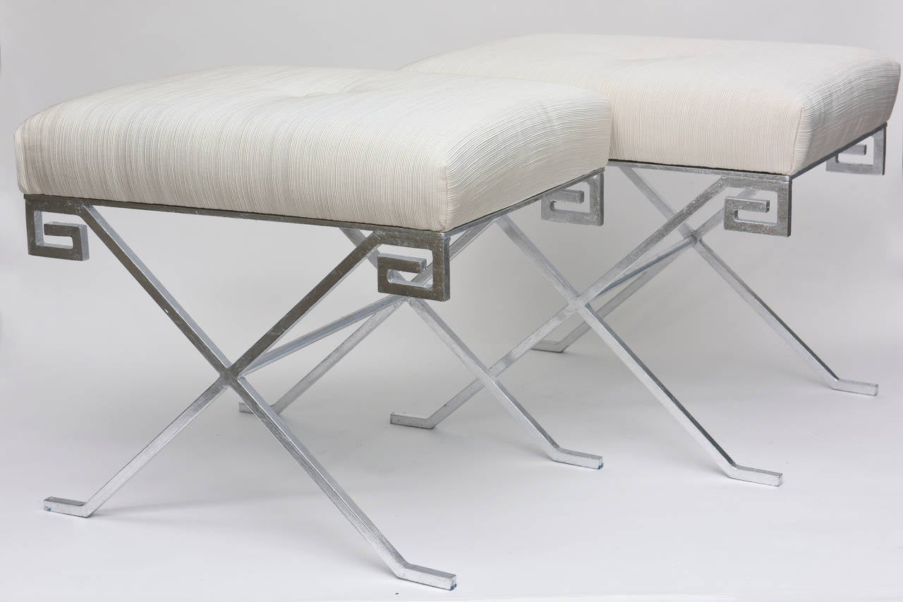 These timeless and elegant silver leaf and newly upholstered benches/stools
have the Classic Greek key design with X frames.The Greek key has withstood all tests of time and is forever moderne. The lovely new upholstery is an off-white to white