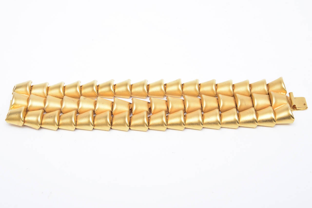 This sculptural bracelet of multi-directional rows of inverted triangles is gold plated. There are 3 rows. It is signed on the clasp; Marcy Feld and it is from the 80's. It is modern, now and tres chic!  It will go day to evening. Fits the wrist
