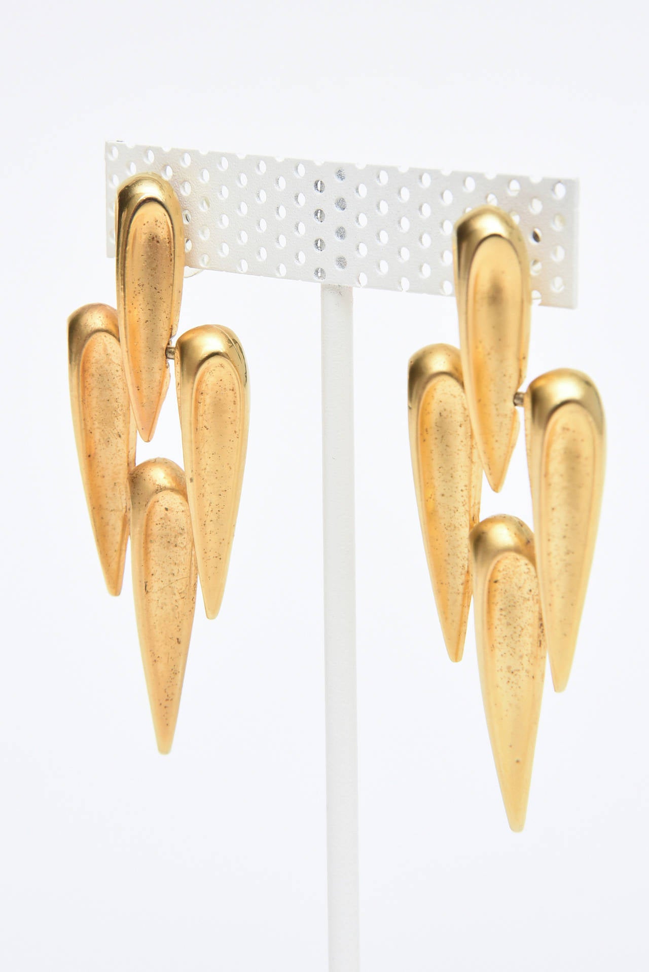 Four teardrops form a sculptural design in these gold plated pierced earrings that are so modern and timeless. 
These are of the contemporary look and design. These could go day or evening.
They are by Park Lane.
