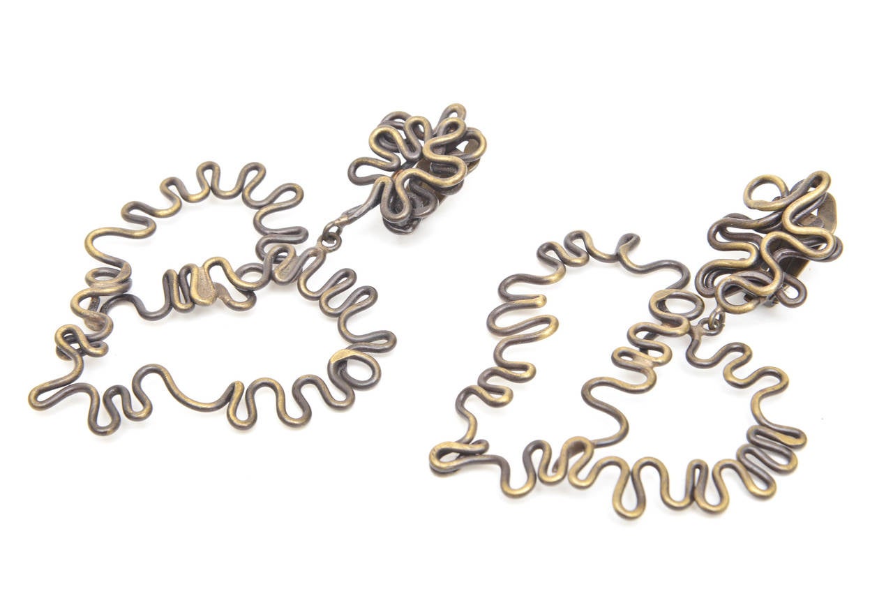 These studio vintage brutalist brass clip on earrings are so sculptural! Their hand crafted form is the shape of a heart. They have a studio look and feel to them. The twisted squiggly scripted artistic delivery make these earrings one of a kind as