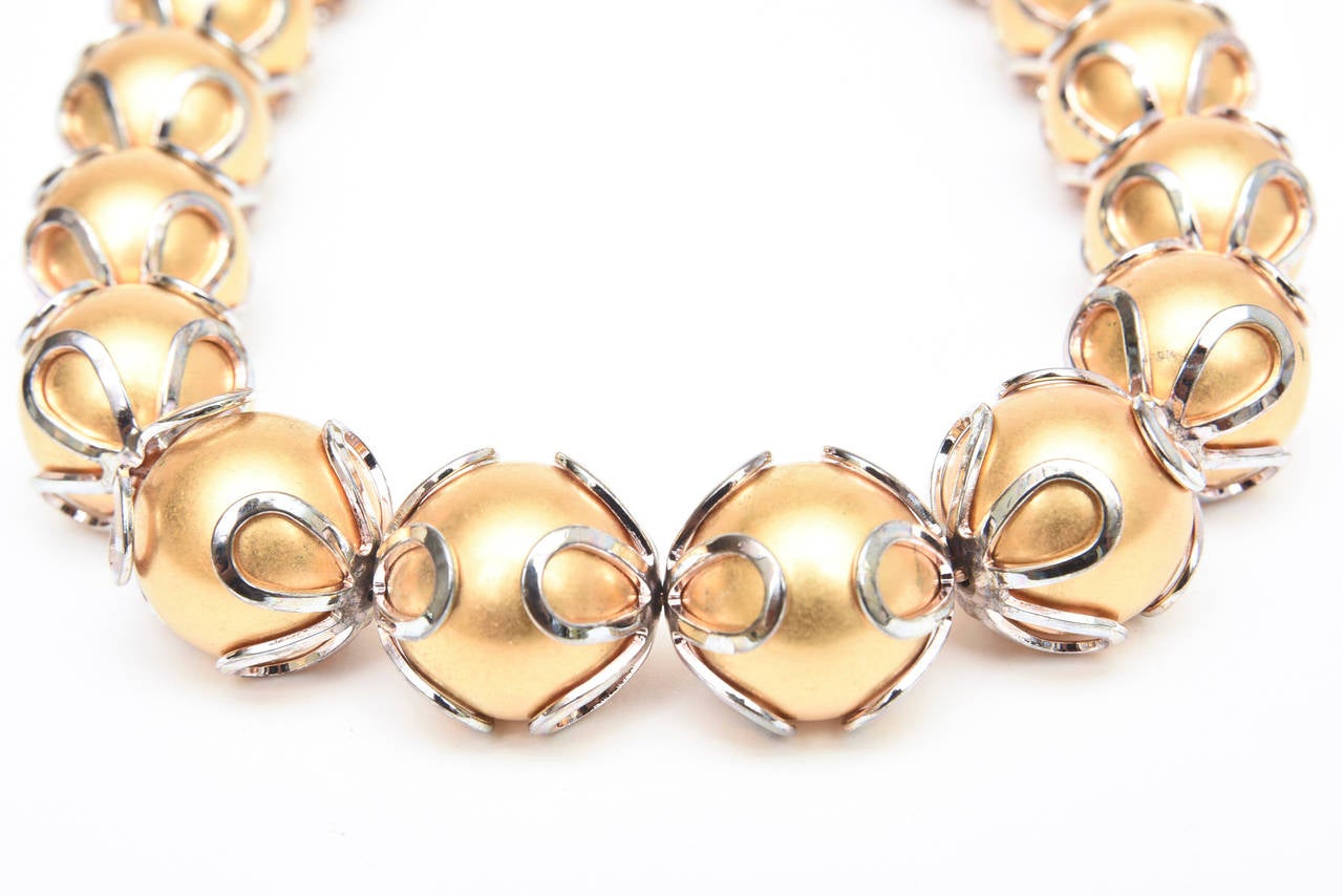 This is the original signed vintage Anne Klein necklace from the 80's. This is when she was still living and designing. It is rich looking gold balls with a silver loop overlay. This has a great presence and is forever wearable for all seasons. It