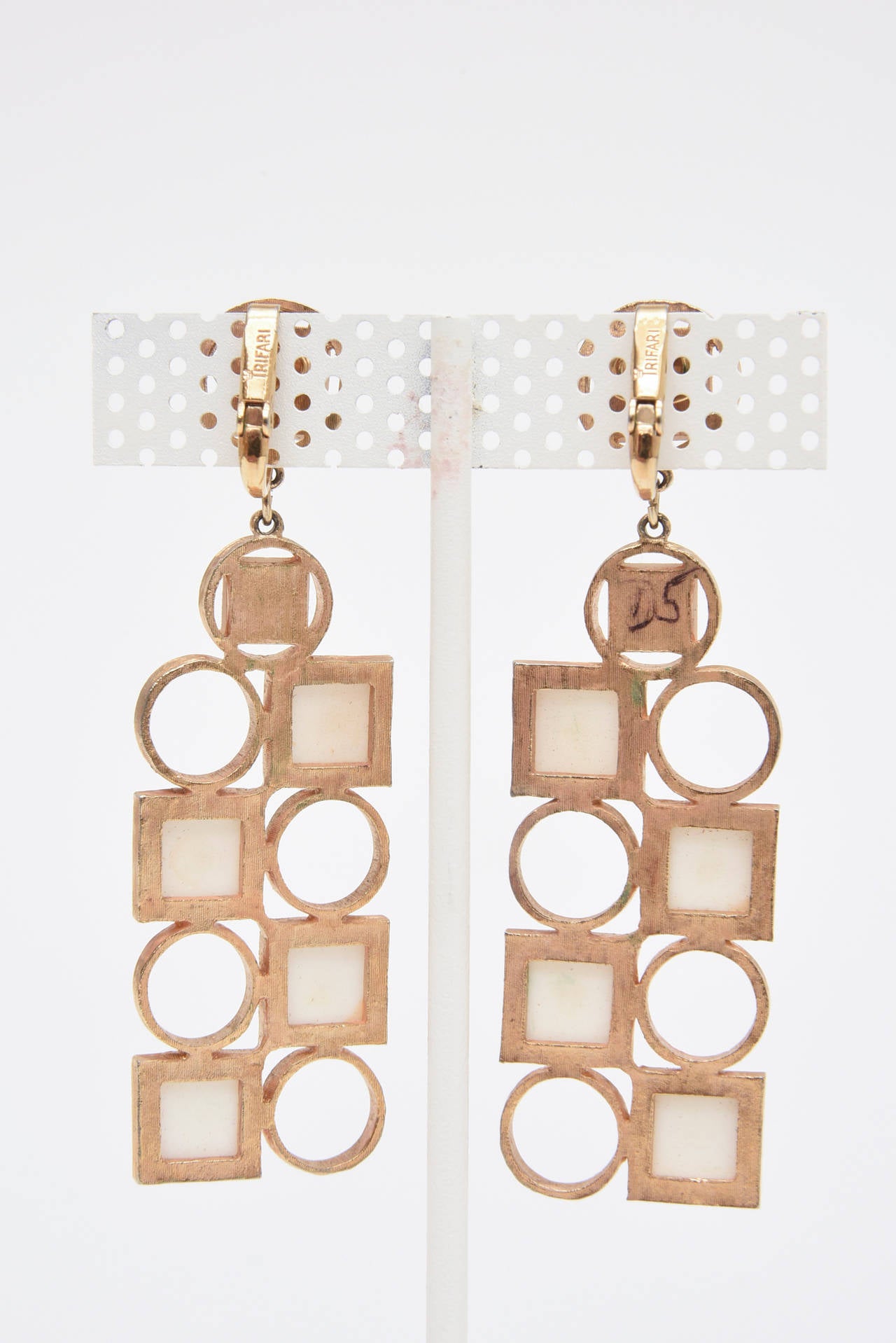 These fabulous, dramatic, geometric Trifari long dangle clip on pair of earrings are signed Trifari. The white enamel and gold plated dramatic look are a show stopper.
They can be worn day to evening... and look great with all white...or black for