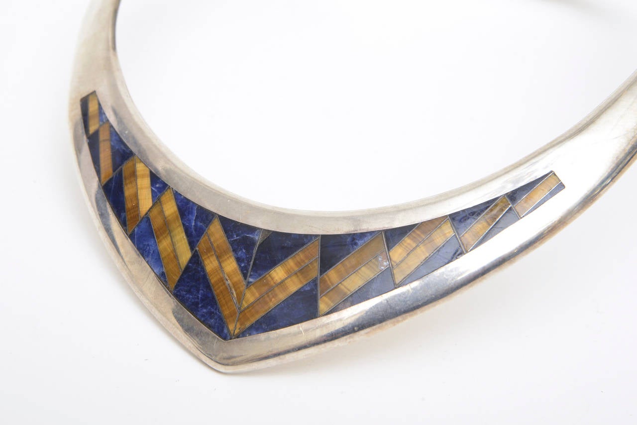 The shape of the V and the beautiful pattern of the combination of the tigers eye and lapis lazuli against the sterling silver make this hinged collar necklace a great piece. It is very becoming on the neck and actually elongates your neck and