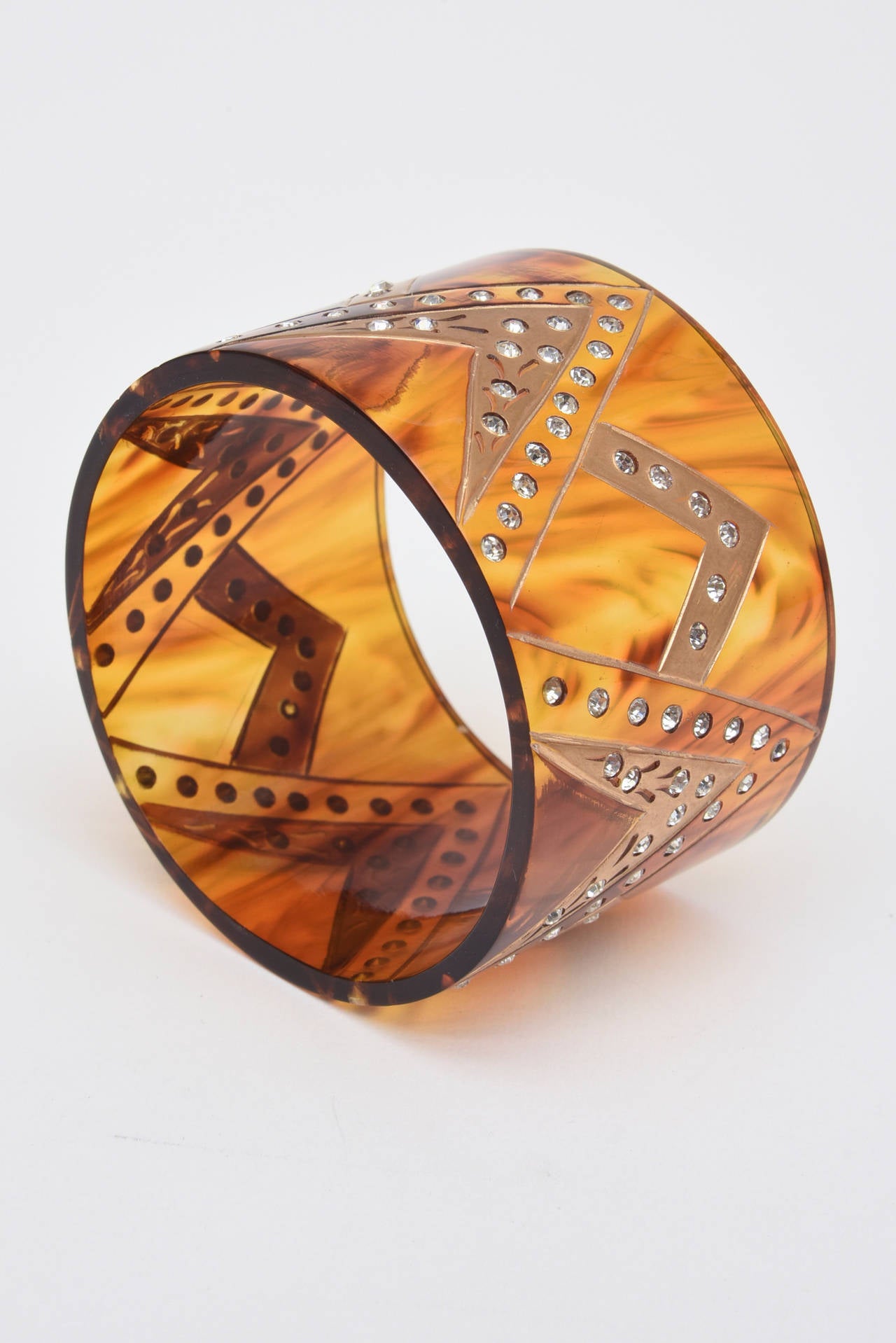 This French wide cuff bracelet has inverted V's  with gold applied and rhinestones adorning the v patterns.. It is amber colored tortoise resin. It has an Art Deco look but from the 80's. The interior of the cuff is 2.5 Inches. This is perfect for