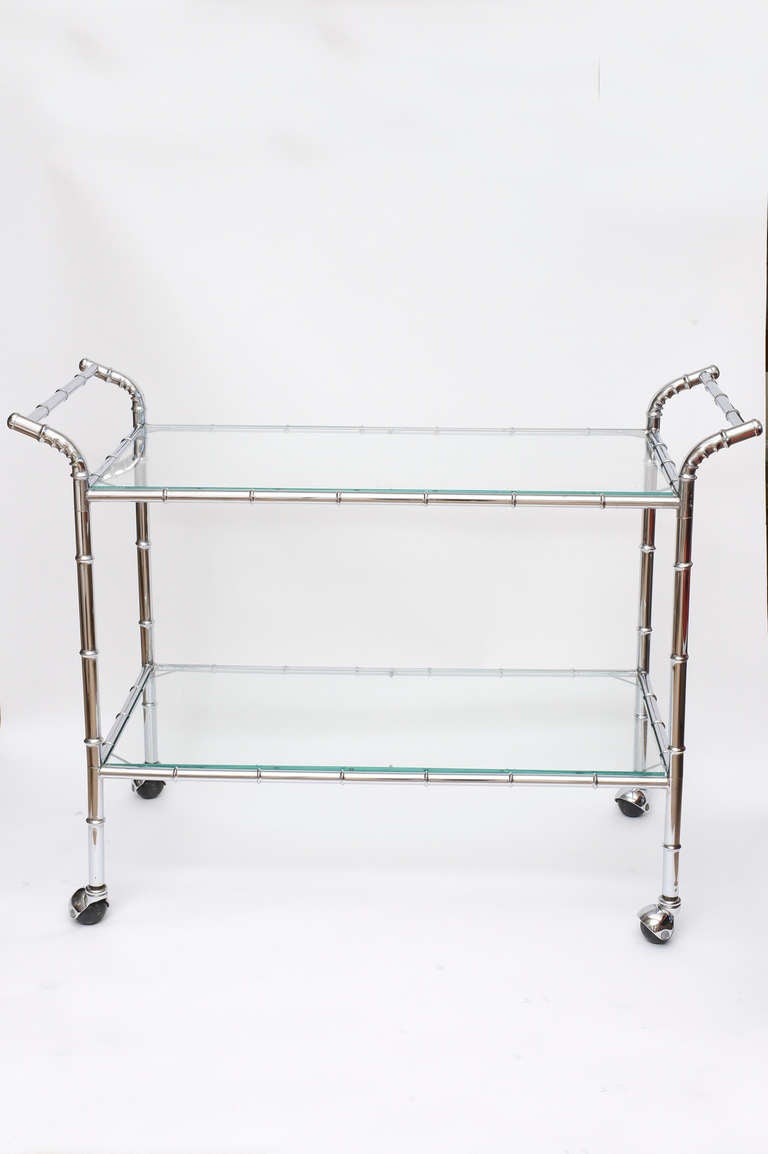 This two tiered polished chrome bar cart / serving cart has the original wheels.
Great for ample serving and wheels around perfectly.
The top shelf height is 25.5