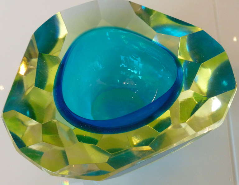 The most brilliant and intense  shade of turquoise meets yellow/chartreuse on the outside in this diamond faceted surround flat cut and polished Geode italian
glass bowl. it is thick and heavy and rings with amazing play of juxtaposing colors of