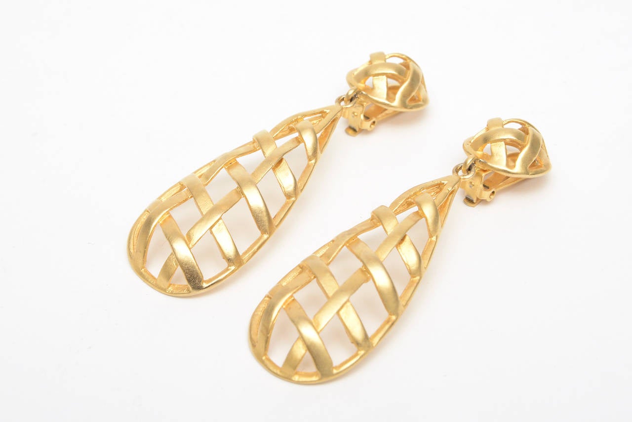 This lovely pair of vintage gold plated dangle clip on earrings that have a criss cross design in a cage like form. They are beautiful and dramatic on. They are 3.25