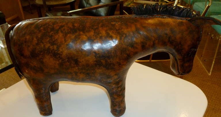 This period leather donkey foot stool by Abercrombie & Fitch is certainly
delightful and weathered. The worn look, yet good condition gives the donkey even more handsome appeal. It is stamped on the back of the ear; Liberty of London.
It is not