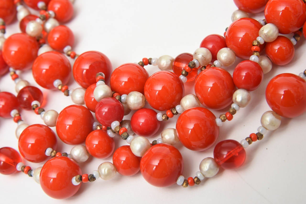 This signed fabulous vintage Miriam Haskell 5 strand orange to tomato red glass bead signature necklace with freshwater faux pearls and seed beads has all the signs of  a true period Haskell; the flower clasp, the open gold coverlets and the