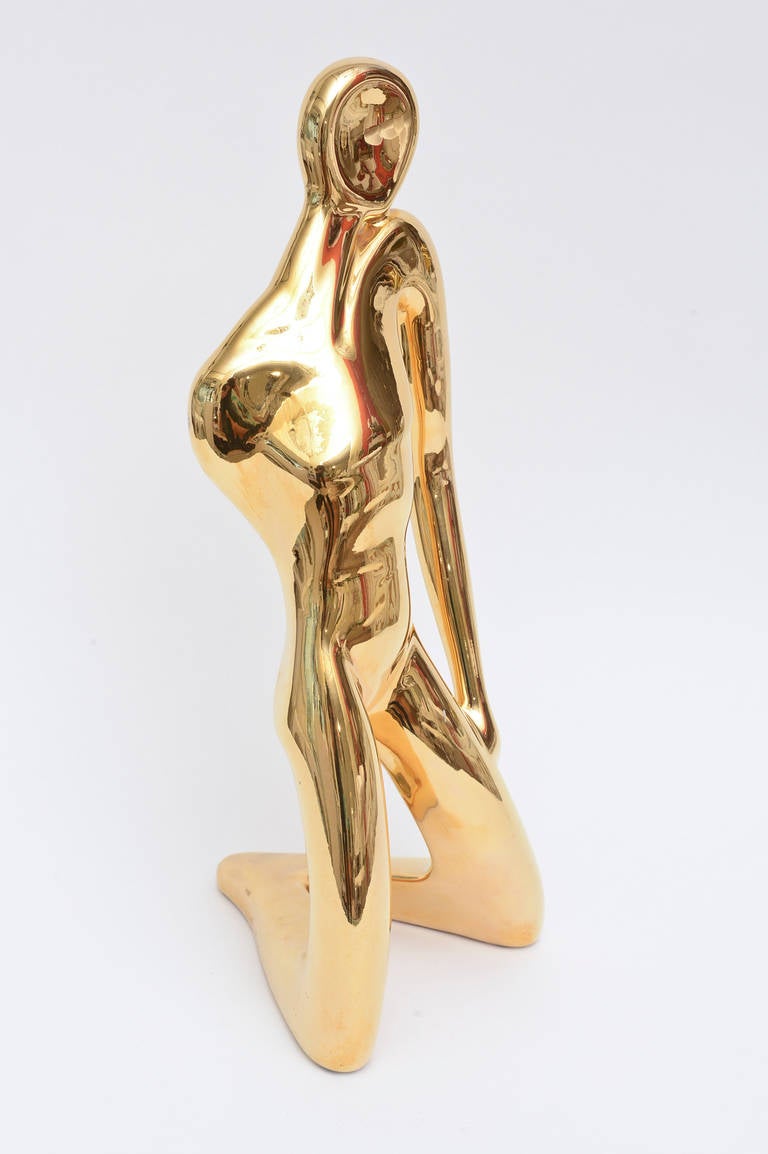 This California ceramic company called Jaru makes this 1980s tall sculpture of gold-plated over ceramic with abstract faceless attitude! It is definitely female form with female attributes. Richness in delivery and abstract in form. One arm is