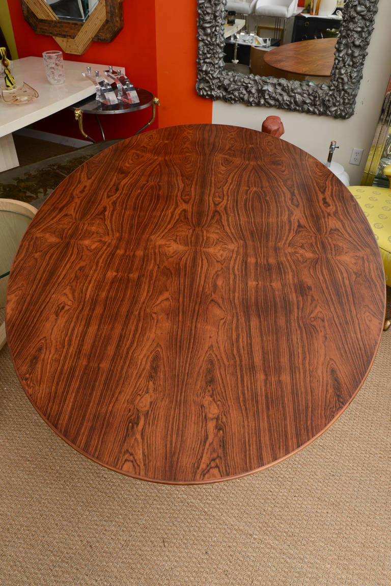 The magnificent rosewood top of the Knoll oval dining table  and or desk has beautiful variations in the wood. It has beveled radius corners throughout the diameter.
The splayed legs of the heavy chromed steel base is classic and modern.
This has