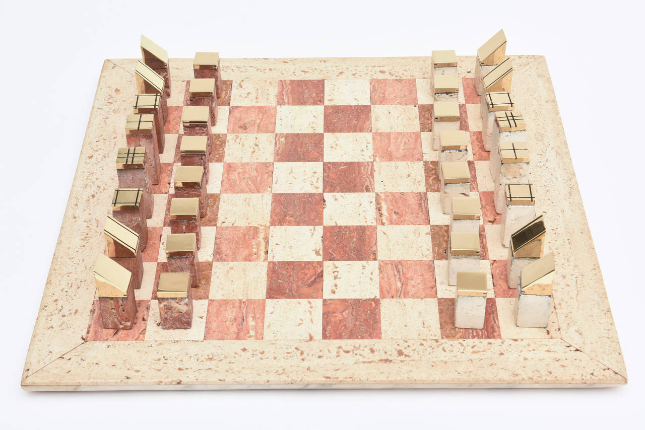This amazing and dual Italian vintage travertine and brass vintage chess set is now so modern. The players are all travertine and have polished brass modernist tips. It has an earthy quality to it mixed with modern elements. The two colored