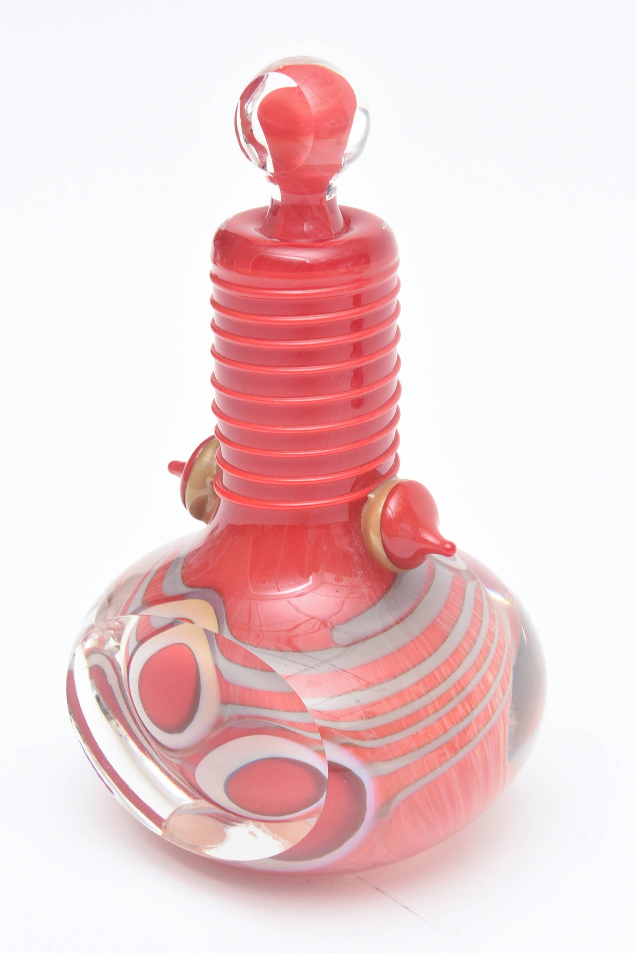 The amazing colors of layers of blue red to gray to white to gold brown play in this signed and dated bottle/perfume bottle/ glass object by American Glass artist: Robert Levin.
He is a listed artist and this is one of a kind. It has flat cut