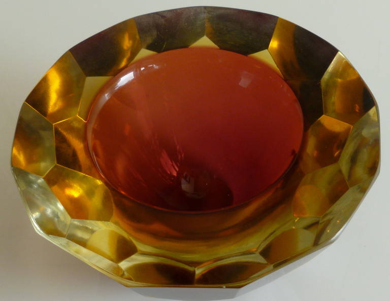 This little gem of an Italian Murano sommerso  geode glass bowl is exquisite. It is multi faceted diamond cut. The top is flat cut polished It is light cranberry on the inside and amber on the outside which produces a brilliant amber jewel. These