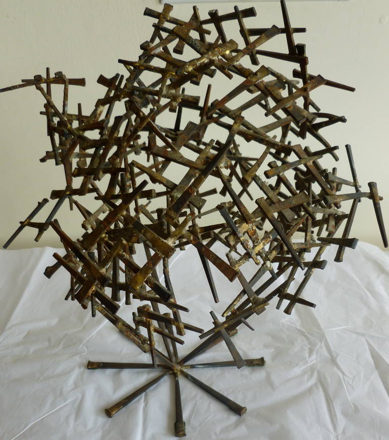 Cement nails put in random form make up this one of a kind Brutalist tabletop abstract sculpture. Some nails have been painted with gold others not
Looks like a world globe. May be the work of Mark creates. The nails have patinated from age.