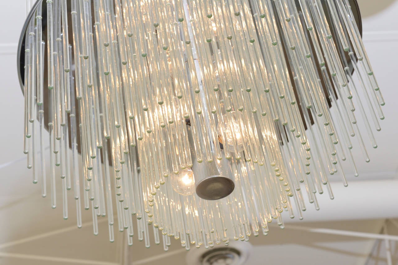 This massive Gaetano Sciolari for LIghtolier chandelier made of 240 glass rods  of 3 different lengths and a chrome cage makes a simple but chic statement. 
It glistens with light. The longest rod is 20