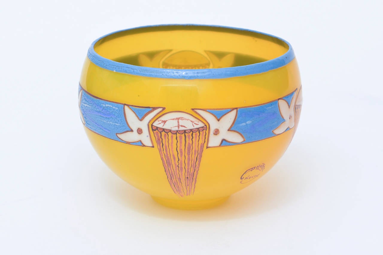 Cette jolie petite coupe obscure en verre Art déco soufflé à la main par l'artiste français Andre Delatte présente des couleurs vives de jaune, de bleu ciel et de rouge à brun rouge. L'art de deux des sujets préférés de l'artiste : le feuillage et