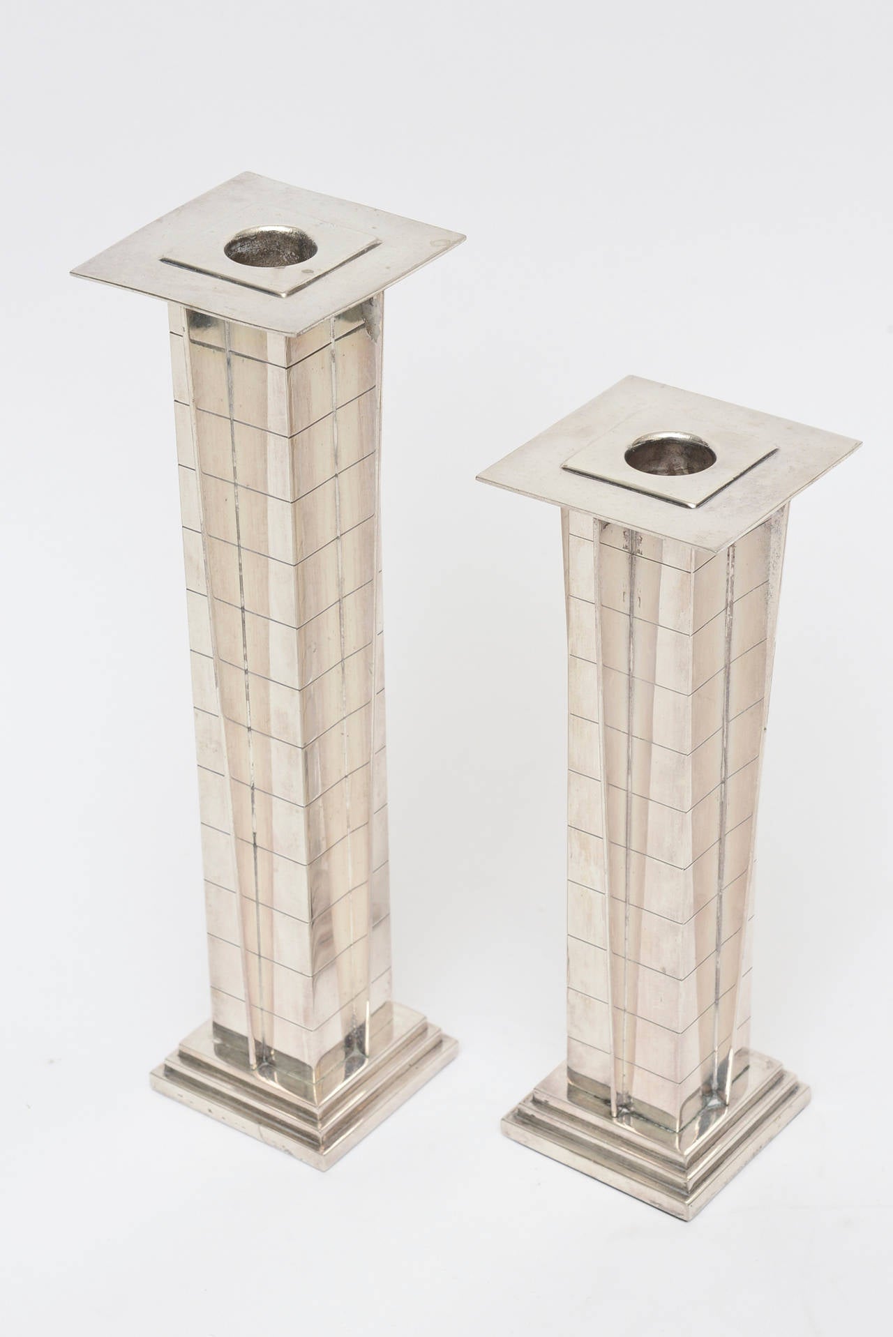 The two different sizes of these amazing and stunning vintage silver plate Art Deco style candlesticks have the squared design that make up the skyscraper look. These are from the 1960s. Elegant and hard to find! The smaller size of the candlestick