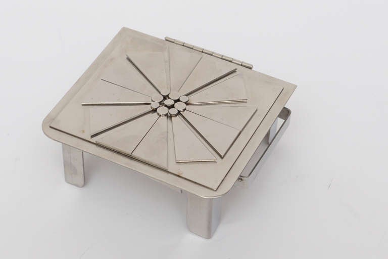 This signed stainless steel one of a kind hinged box by Stanley Szwarc box has a beautiful flower motif in modern form with a hinged top. The raised and cut stainless modern petals have 9 round centre circles representing the inside of a flower. It
