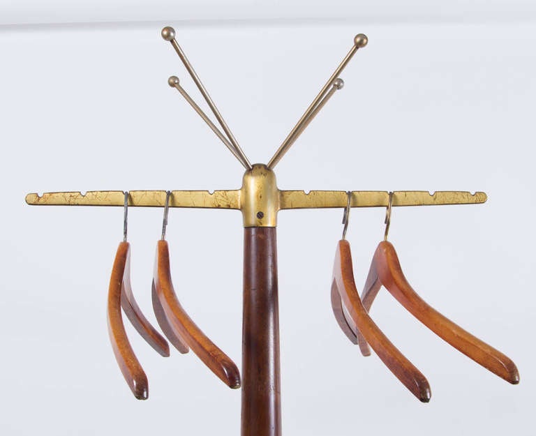 Elegant coat stand by Gio Ponti with solid brass four-legged base,
hat tree and brass arms with original walnut hangers.
Solid walnut body with tapered shape and brass band.
 