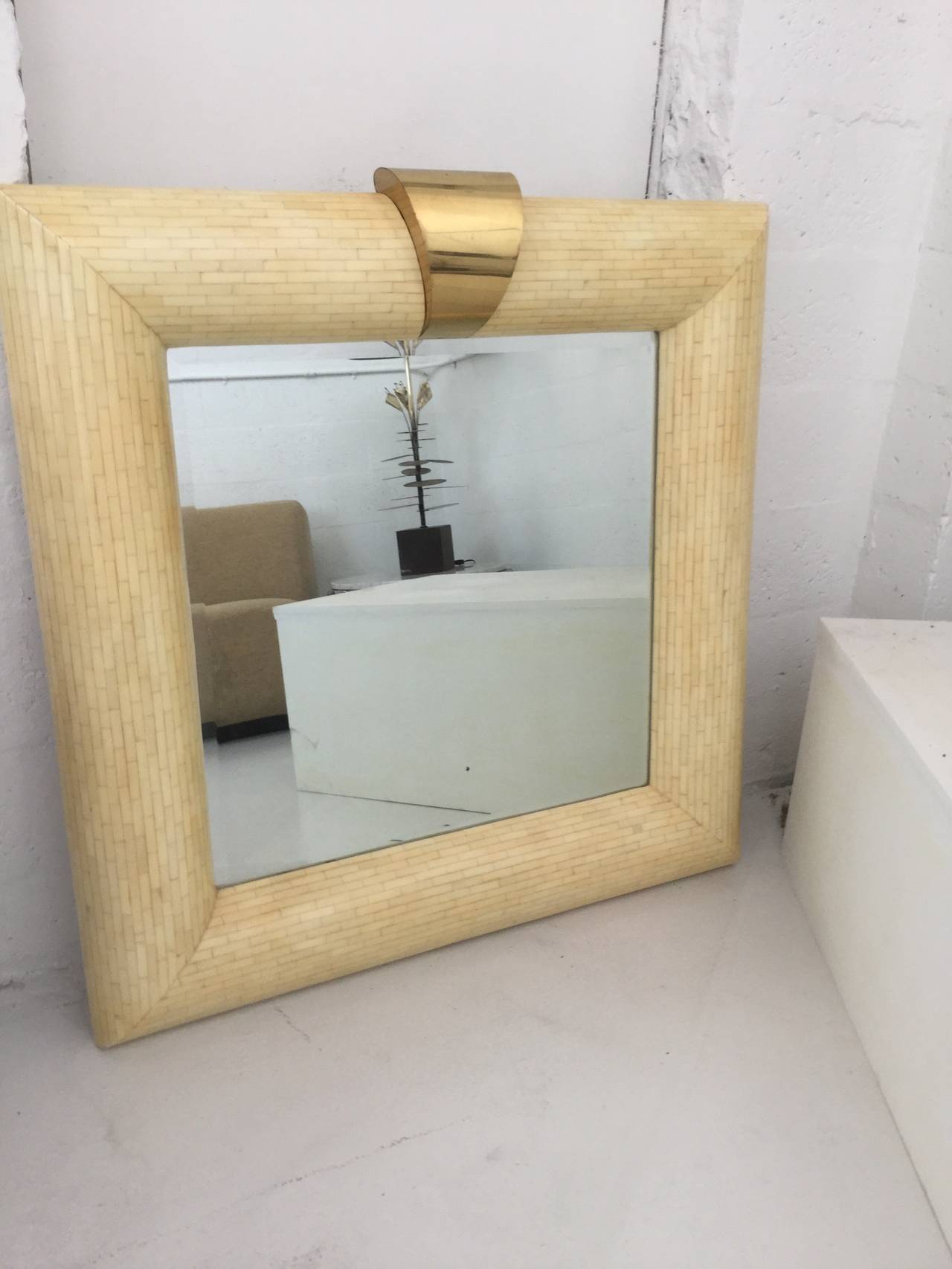 Wall Mirror in the style of Karl Springer 
In tasseleted bone veneer with 6.5" wide,
 3.75"deep frame,
polished brass key at the top.
  
