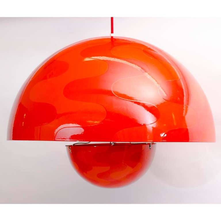 Iconic Flower Pot Pendant Light by Verner Panton.
For Louis Poulsen in 1962,
Bright red and orange Op-Art pattern 
enameled on outside porcelain, 
White enameled interior, porcelain bulb socket,
original red silk wrapped cord.
Label inside the dome.
