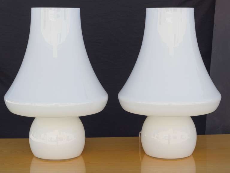 Pair of Murano glass table lamps originally
designed by Max Ingrand for Fontana Arte.
Both the base and the shade are one continuous 
Milky glass form illuminated from the inside.
De Majo sticker attached to the side.