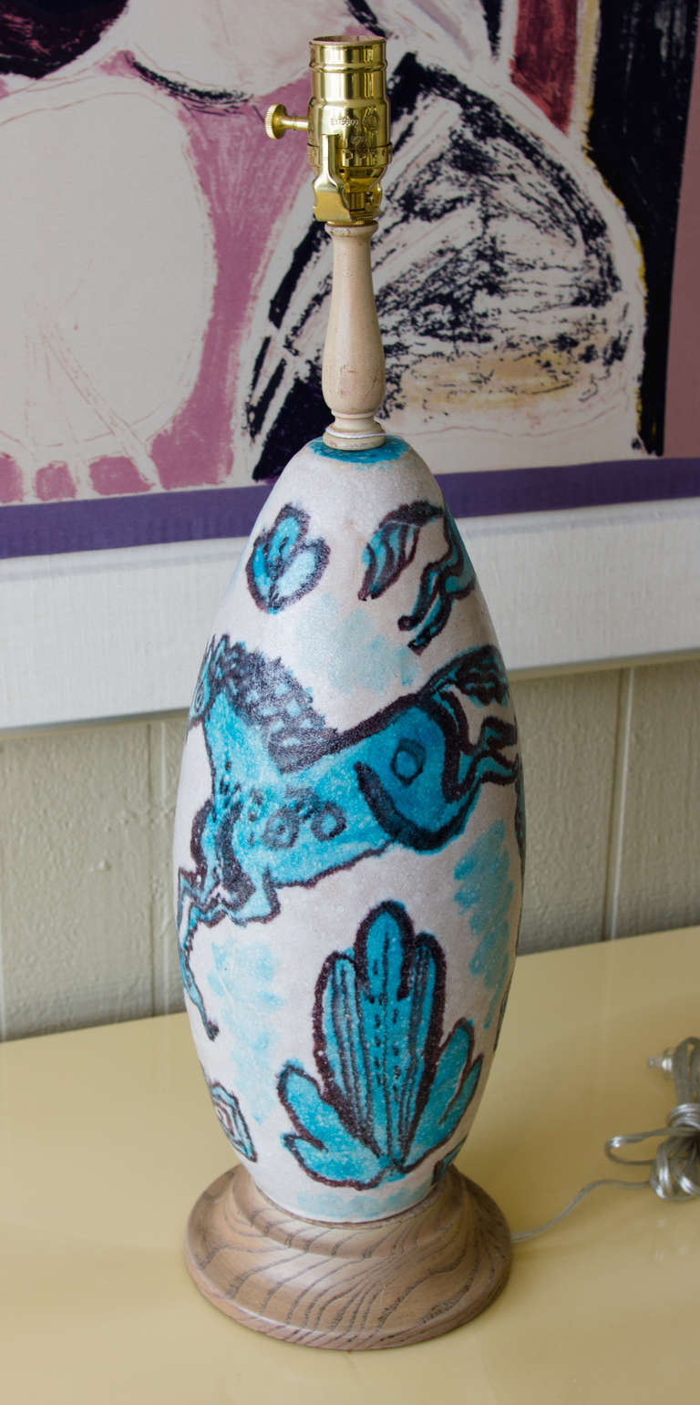 1950's Table Lamp by Guido Gamboni in glazed 
pottery with turquoise , black horses image painted on 
Cream background .