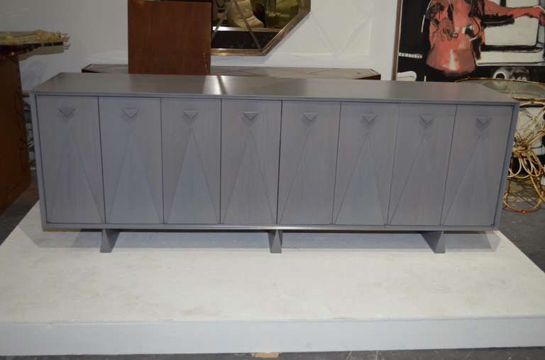 Midcentury Long Buffet featuring four sets of folding doors
with raised triangular design panels, triangular pulls and legs.
Wide cutlery drawer at the middle and
adjustable shelves on each side.
Displayed at ENTREPOT,Miami.
By appointment only.