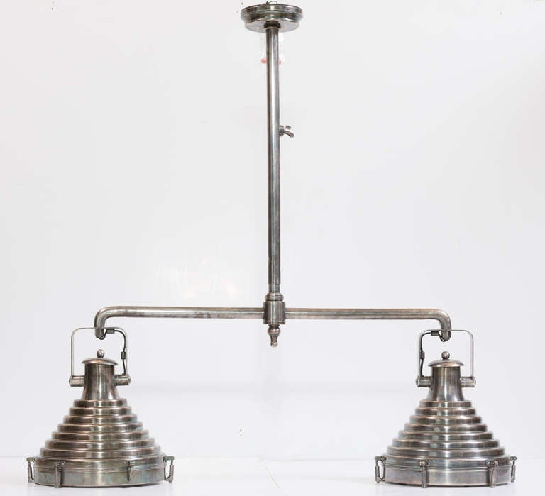 Industrial heavy duty pendant light fixture,
with two 12" diameter rotating and adjustable
steel reflectors mounted on a nickeled steel cross bar
suspended from a steel centre stem.
 