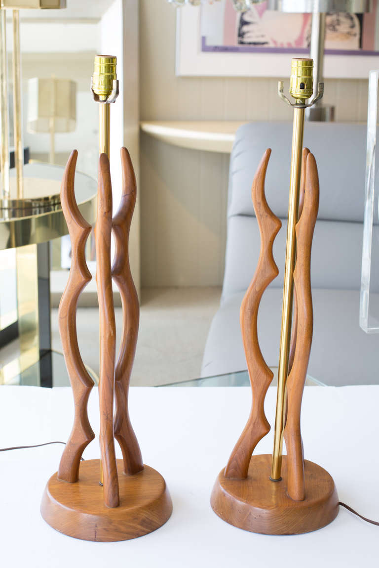 Pair of table lamps with curved solid.
Walnut in organic forms, brass tube stem.
Supported by round wood base.