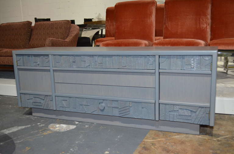 1960s grey Credenza by Lane Furniture,
with sculptural decorative panels
on top and bottom drawers fronts.
Fully reconditioned with cerussed grey finish.