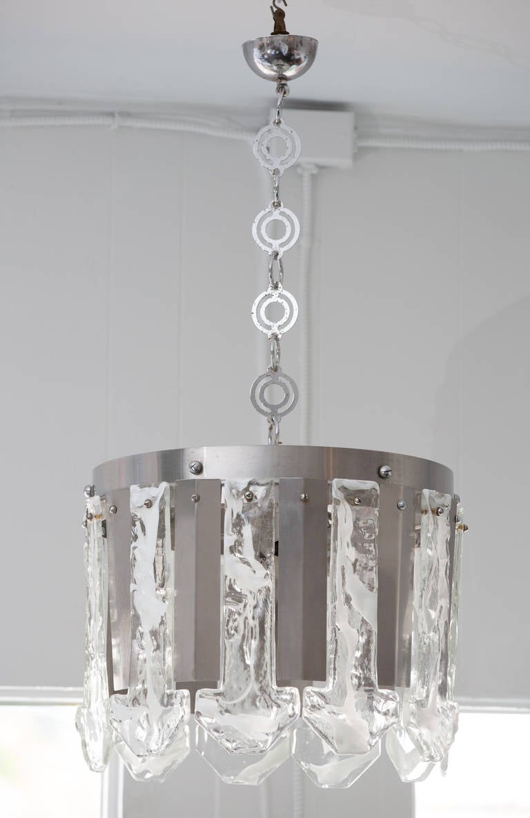 Murano texture glass and steel frame chandelier by Mazzega.
Suspended on a matching 30 inch long decorative chain.
Four sockets attached to the interior frame.
