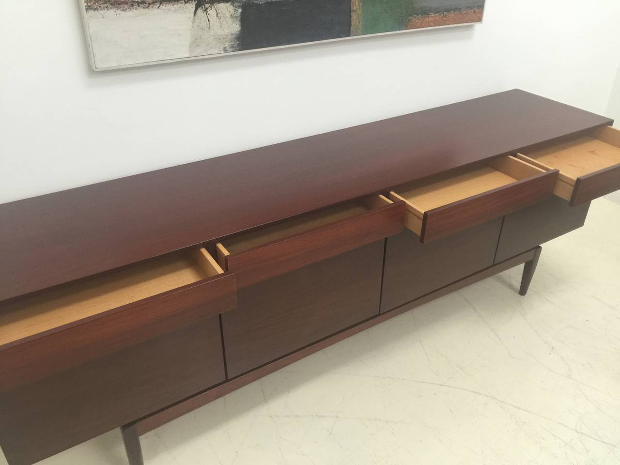 Long Walnut Buffet with four doors and four top drawers.
Elegant detail with integrated finger pulls at the top of book 
matched solid wood doors.
Solid Walnut 11'h tapered legs with a floating stretcher.
Additional four lined silver drawers