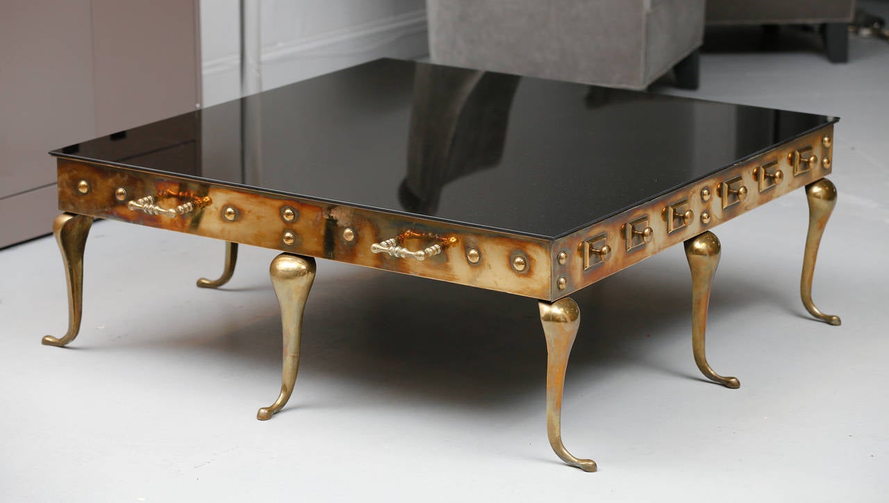 1960's Grand scale Solid Brass Coffee Table
by Maison Jansen for Mastercraft
Featuring cabriole legs, brass frame with
button details and handles, black glass on
Brass top under.


