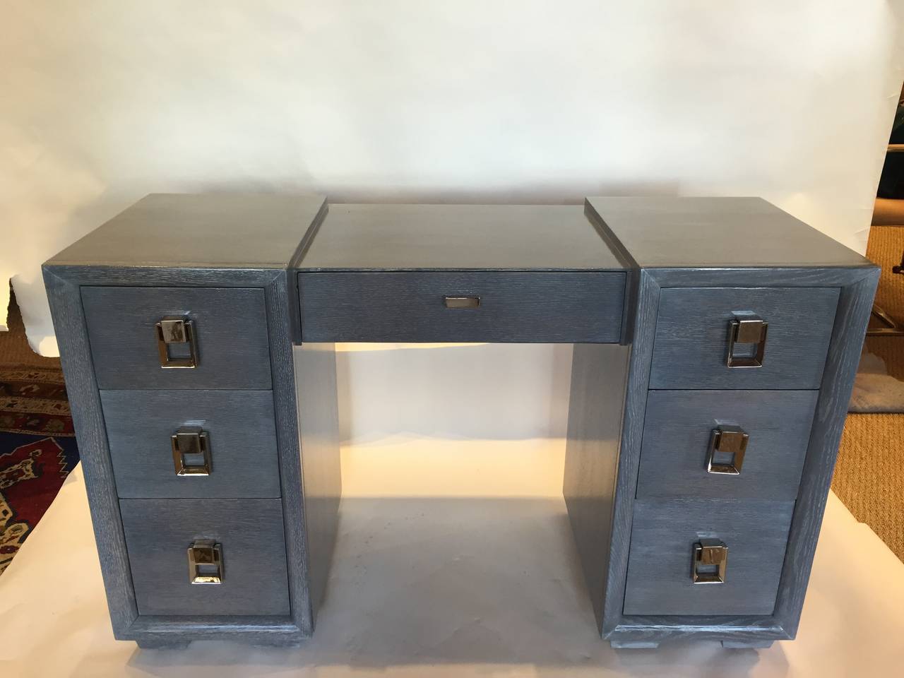 This beautiful piece is part of a bedroom set which includes a double-commode chest of drawers and a tall-boy. All in this elegant and masculine grey cerused finish which accentuates the wood grain.

This desk or vanity has six ample lateral