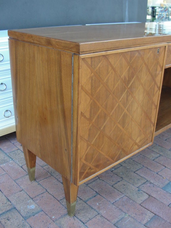 Wonderfully crafted, this rare cabinet has an inlay lattice work in center drawer and two side doors. Features open center space perfect for today's T.V. equipment or books. Tapered legs with sabot and two keys for side doors with interior shelf.