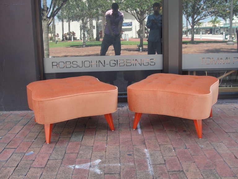 Oversized and heavy in quality, these 1940's ottomans have been carefully restored in lush orange velvet and matching orange lacquered flared feet, possibly designed by Billy Haines.